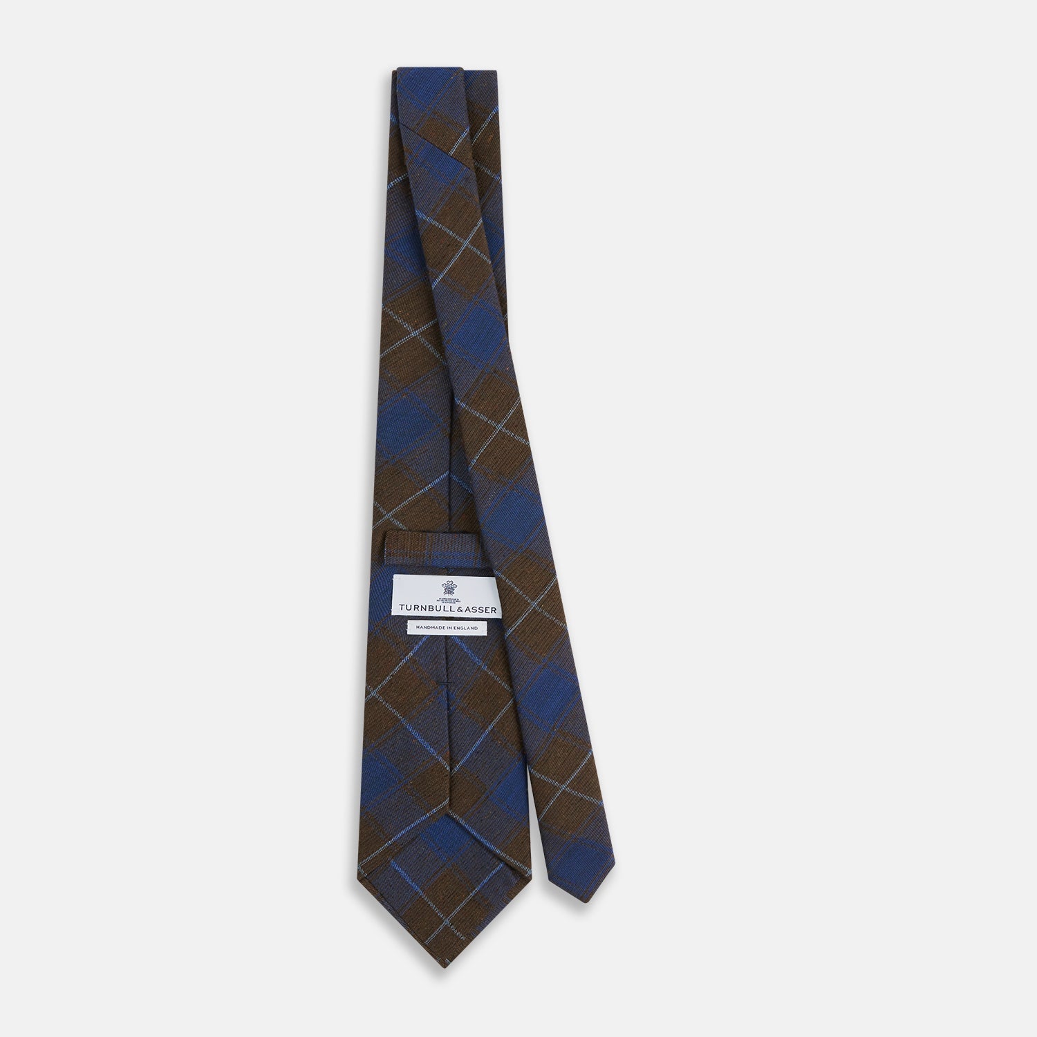 View 4 of product The Turnbull & Asser Blue and Brown Tartan Silk Blend Tie, rolled up to show intersecting patterns, is displayed against a plain white background.