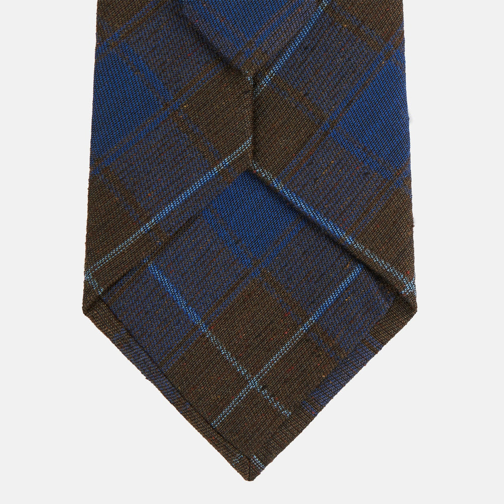 The Turnbull & Asser Blue and Brown Tartan Silk Blend Tie, rolled up to show intersecting patterns, is displayed against a plain white background.
