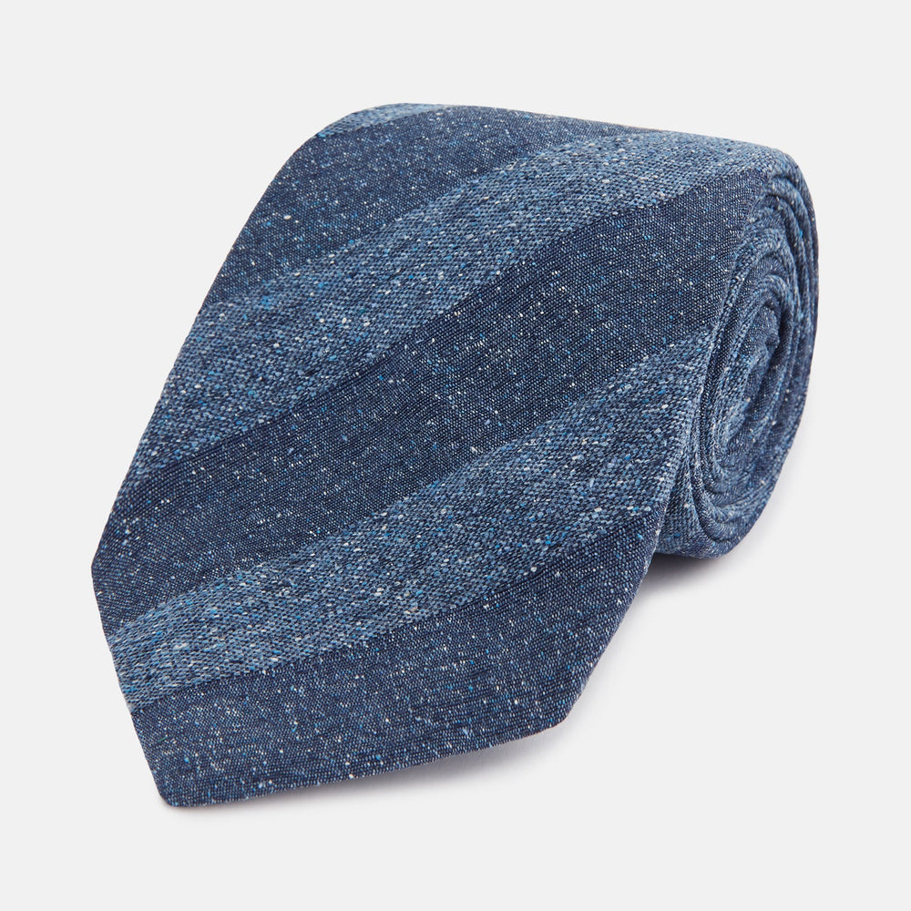 The Turnbull & Asser Blue Block Stripe Silk Tie, featuring a refined striped pattern, is elegantly showcased rolled up against a plain white background.