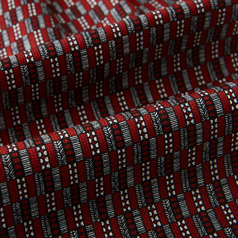 Close-up of the Red Hatched Mosaic Printed Silk Cravat by Turnbull & Asser UK, featuring black and white geometric shapes, parallel lines, and a textured finish in a classic British style.
