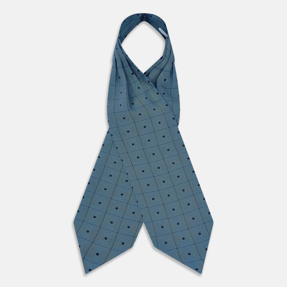 The Blue and Navy Concentric Square Printed Silk Cravat from Turnbull & Asser UK features a geometric blue and white design on a dark background, creating an optical illusion—an elegant wedding accessory.
