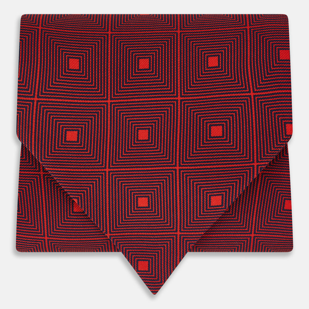 The Tulip Red Concentric Diamond Printed Silk Cravat from Turnbull & Asser UK features a bold red and black geometric pattern, creating an optical illusion effect and smart British style.