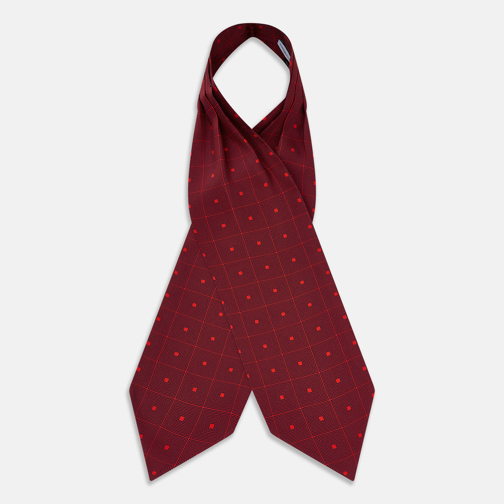 The Tulip Red Concentric Diamond Printed Silk Cravat from Turnbull & Asser UK features a bold red and black geometric pattern, creating an optical illusion effect and smart British style.