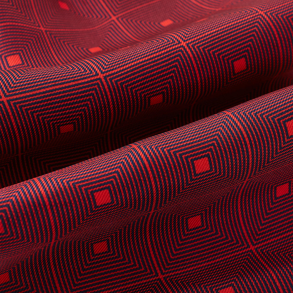 The Tulip Red Concentric Diamond Printed Silk Cravat from Turnbull & Asser UK features a bold red and black geometric pattern, creating an optical illusion effect and smart British style.