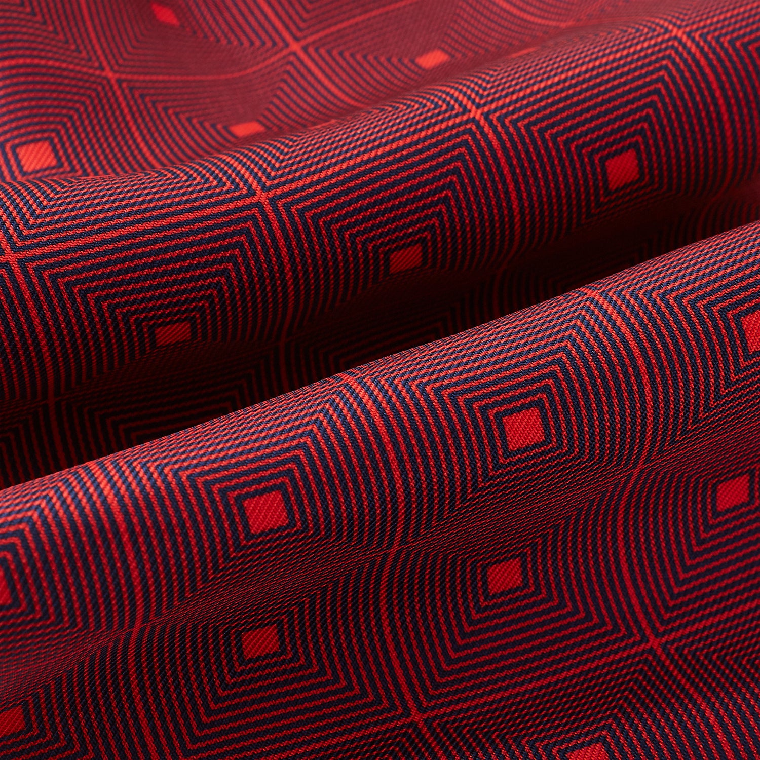 View 4 of product The Tulip Red Concentric Diamond Printed Silk Cravat from Turnbull & Asser UK features a bold red and black geometric pattern, creating an optical illusion effect and smart British style.