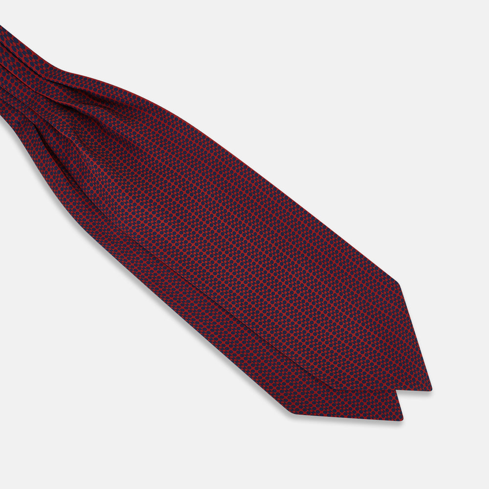 The Red Micro-Dot Bar Printed Silk Cravat from Turnbull & Asser UK features a geometric red and navy micro-dot pattern—a refined accessory inspired by classic British style, perfect for elegant weddings.