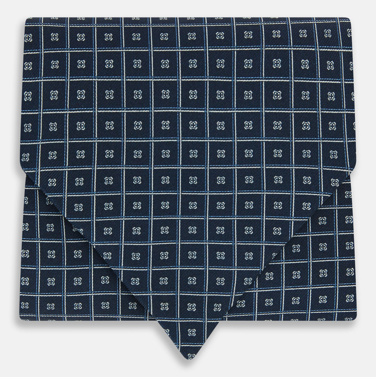 View 1 of product A folded Geometric Navy Quatrefoil Motif Ascot Tie in Silk, featuring a navy ground with a white grid pattern and small quatrefoil motifs in each square.