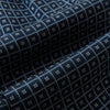 View 4 of product A folded Geometric Navy Quatrefoil Motif Ascot Tie in Silk, featuring a navy ground with a white grid pattern and small quatrefoil motifs in each square.