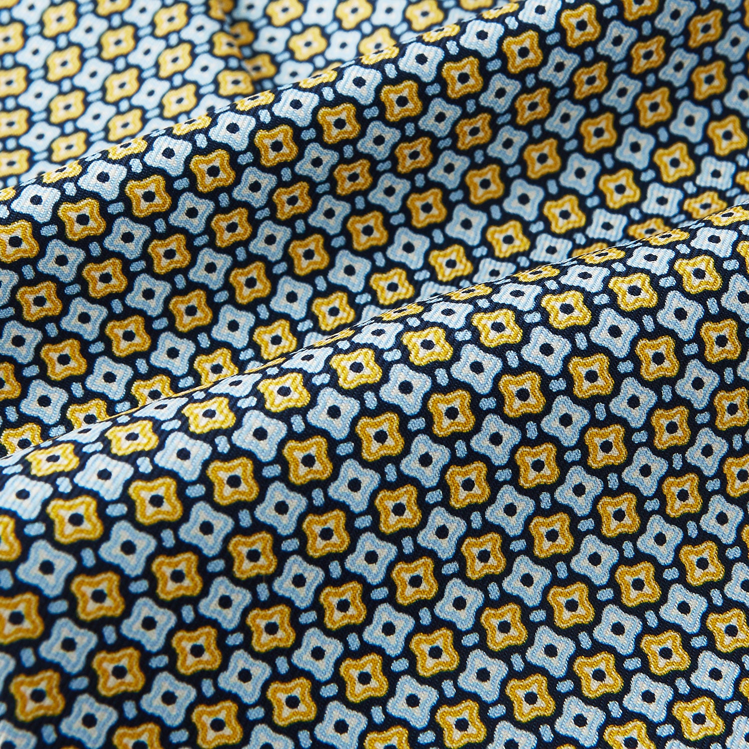 View 4 of product A close-up of Turnbull & Asser UK's Citrus Yellow Abstract Quatrefoil Foulard Printed Silk Cravat shows a gently folded fabric with blue, yellow, and white geometric patterns for a classic British look.