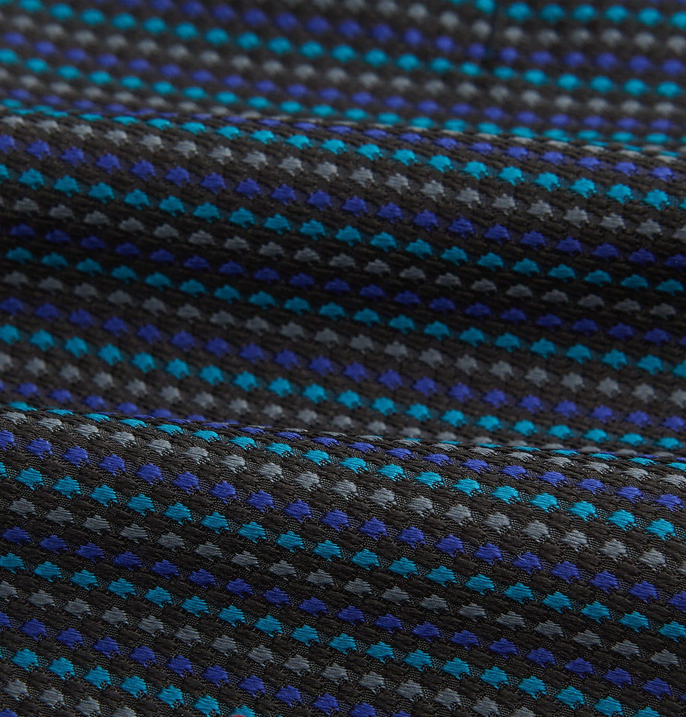 Turnbull & Asser's Navy Multi Silk Cravat pairs perfectly with a folded pocket square featuring a grid of small blue and black dots on a dark background—an ideal touch for adding flair to your next formal outfit.