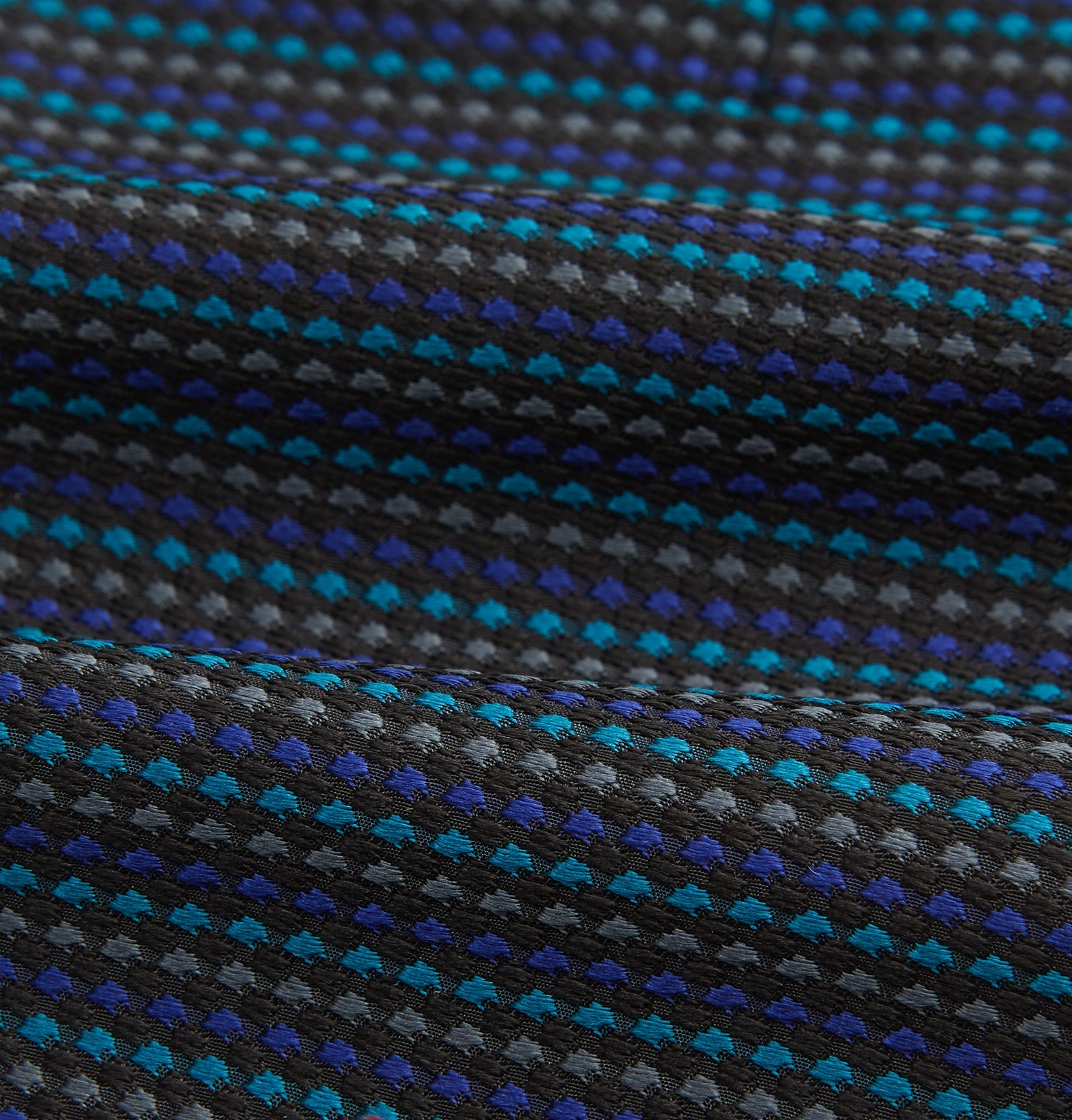 View 4 of product Turnbull & Asser's Navy Multi Silk Cravat pairs perfectly with a folded pocket square featuring a grid of small blue and black dots on a dark background—an ideal touch for adding flair to your next formal outfit.