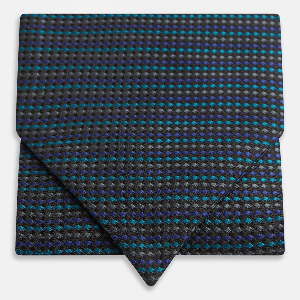 Turnbull & Asser's Navy Multi Silk Cravat pairs perfectly with a folded pocket square featuring a grid of small blue and black dots on a dark background—an ideal touch for adding flair to your next formal outfit.