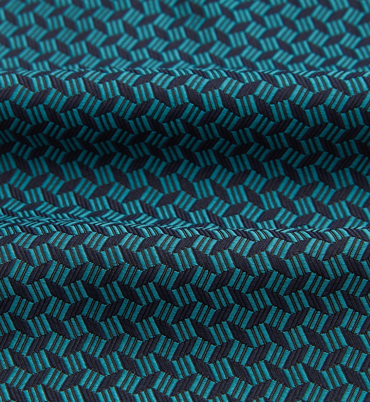 View 4 of product The Turquoise Geometric Silk Cravat by Turnbull & Asser features a striking teal and black pattern—perfect for those who appreciate bold, handmade neckwear with geometric flair.