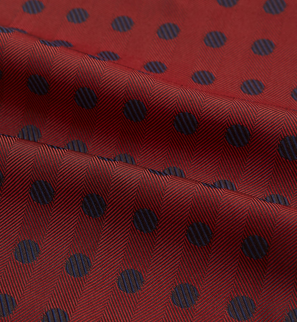 The Turnbull & Asser Red Dot Silk Cravat is a red silk accessory with evenly spaced dark blue polka dots—neatly folded for a sharp finish and perfect for pairing with your favorite handmade neckwear.