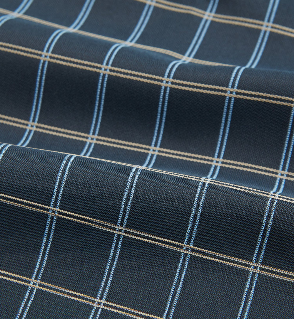 The Navy Fine Double Check Silk Cravat by Turnbull & Asser features a grid pattern in light blue and white lines—an elegant formal men's accessory, neatly folded with the pointed end at the bottom.