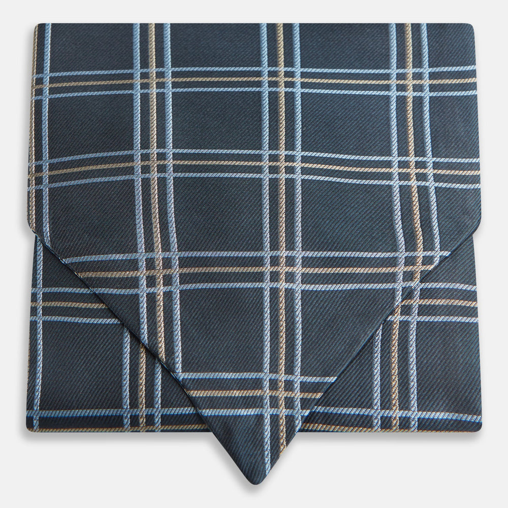 The Turnbull & Asser Navy Triple Check Silk Cravat features a classic navy, white, and light blue plaid design—perfect for adding elegance to any outfit. Shown neatly folded on a white background.