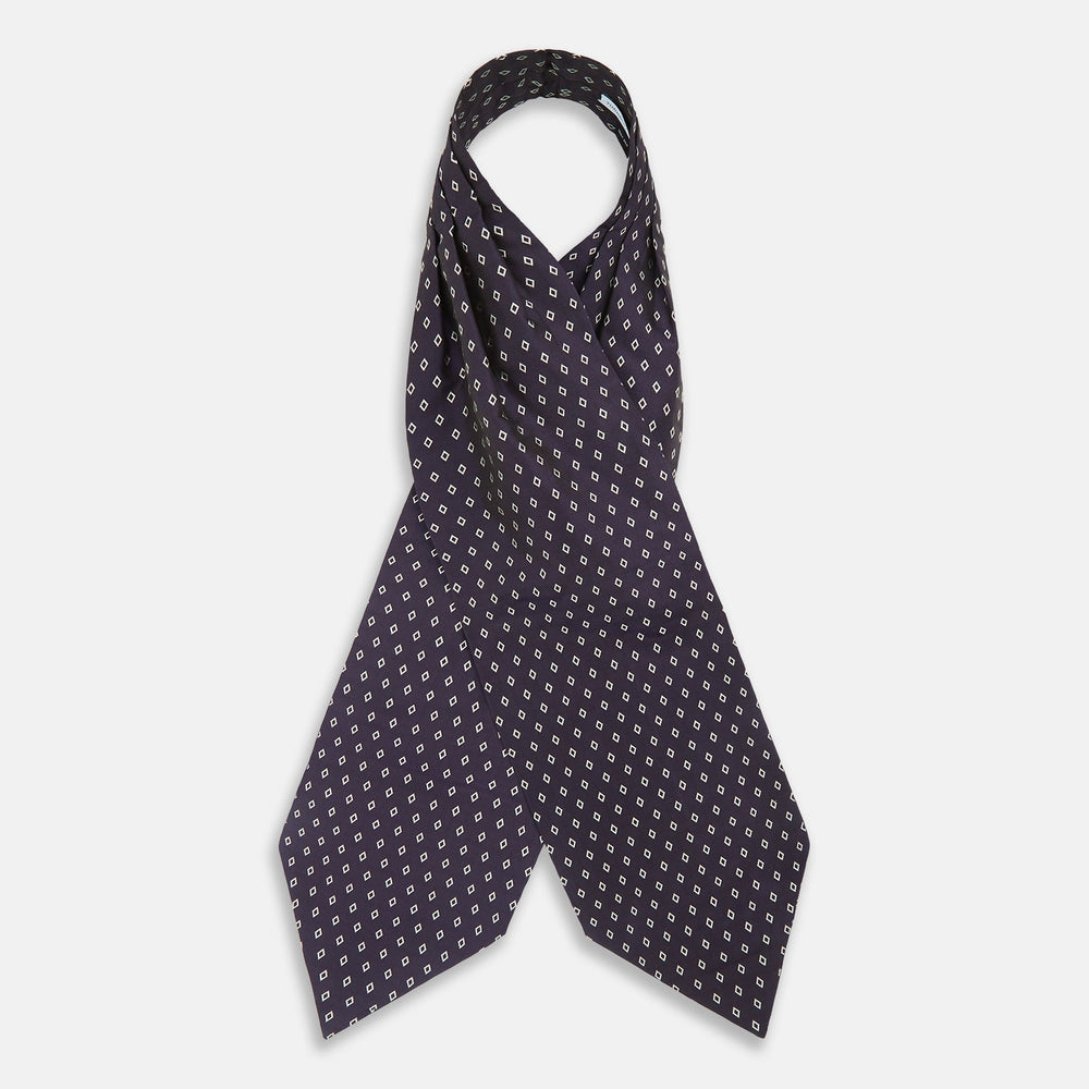 The Turnbull & Asser Blue Diamond Silk Cravat is a refined men's formal accessory, featuring a navy blue base with small white diamond patterns—perfectly complemented by a neatly folded, pointed-corner pocket square.