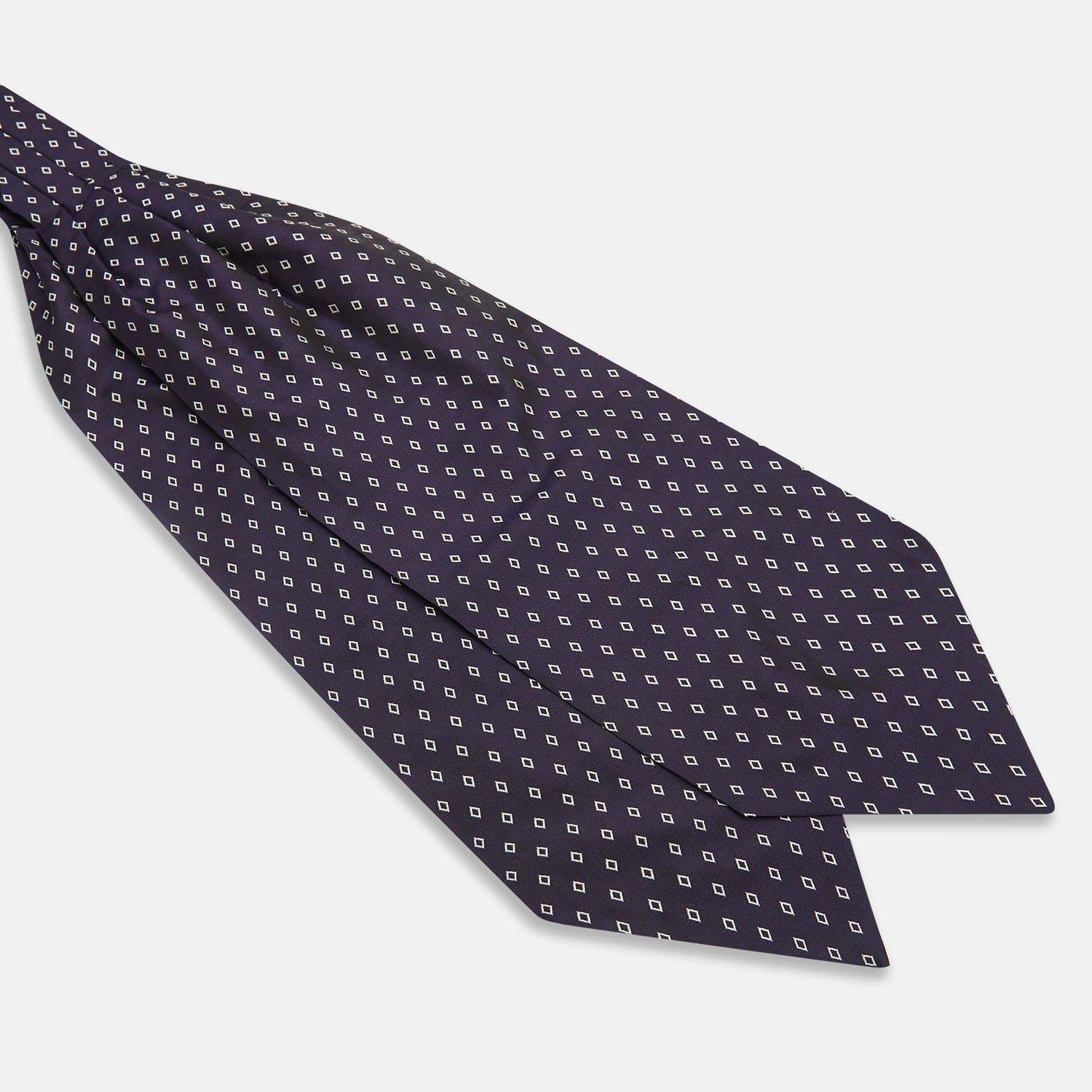 View 3 of product The Turnbull & Asser Blue Diamond Silk Cravat is a refined men's formal accessory, featuring a navy blue base with small white diamond patterns—perfectly complemented by a neatly folded, pointed-corner pocket square.