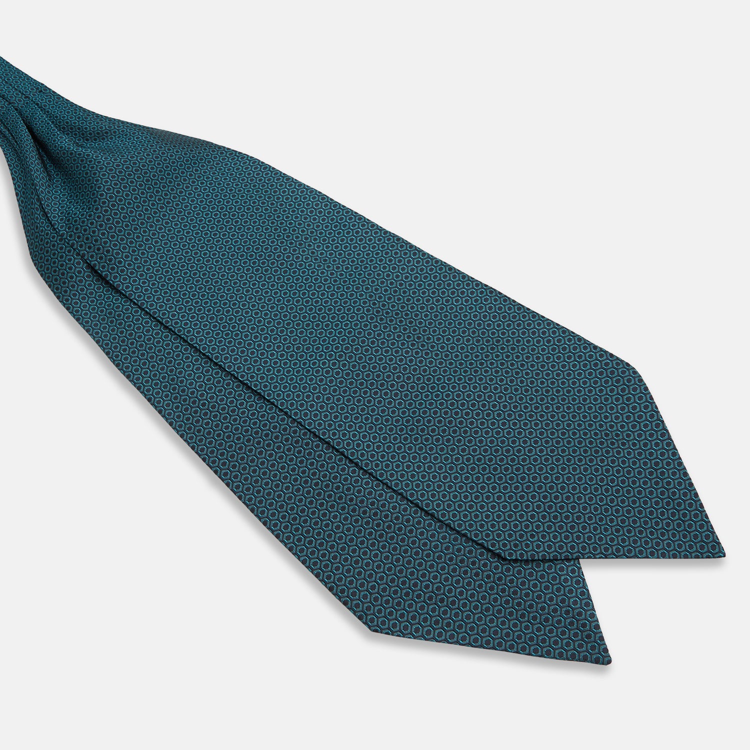 View 3 of product The Turnbull & Asser Turquoise Micro Hexagon Cravat is neatly folded to show a triangular point, displayed with a matching pocket square featuring a subtle hexagon pattern, all set against a white background.