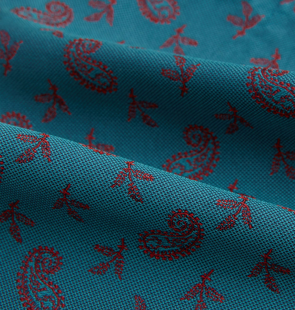 The Turnbull & Asser Teal Paisley Silk Cravat features a refined red paisley and floral pattern, adding a touch of elegance to formal men's attire.