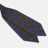 View 3 of product The Turnbull & Asser Blue and Brown Tartan Silk Blend Cravat is neatly folded with sharp creases and displayed on a white background.