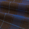 View 4 of product The Turnbull & Asser Blue and Brown Tartan Silk Blend Cravat is neatly folded with sharp creases and displayed on a white background.