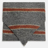 View 1 of product The Red Block Stripe Silk Cravat by Turnbull & Asser features gray textured fabric with two bold red-orange stripes and a pointed tip, reminiscent of handmade neckwear, shown against a white background.