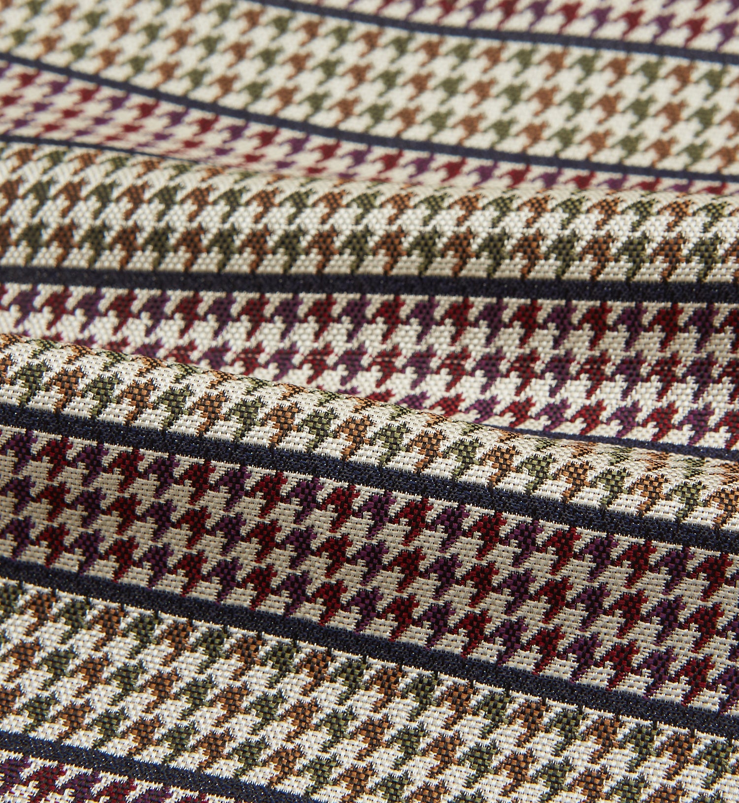 View 4 of product The Turnbull & Asser Brown Puppytooth Silk Cravat features a houndstooth pattern in brown, burgundy, and cream—evoking the refined elegance of a handmade accessory—displayed against a white background.