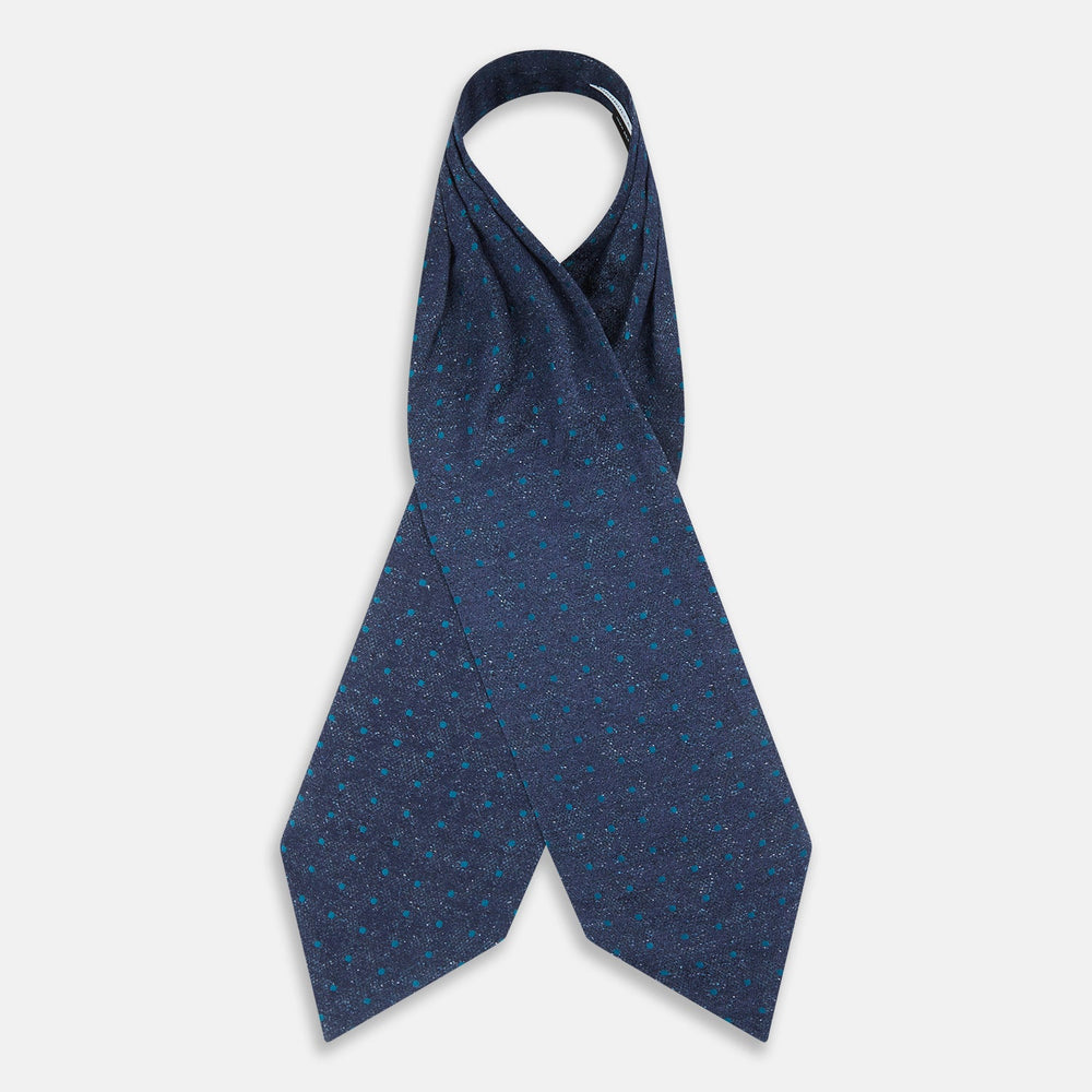 The Teal Micro Dot Silk Cravat by Turnbull & Asser is a formal accessory in textured dark blue silk, with small turquoise polka dots and a pointed edge at the bottom.
