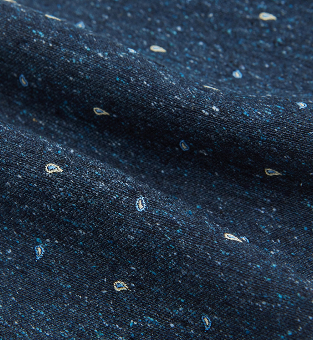 The Navy Micro Paisley Silk Cravat by Turnbull & Asser is a refined men's accessory, featuring subtle white paisley on silk—perfectly paired with a dark blue pocket square for an elegant formal look.