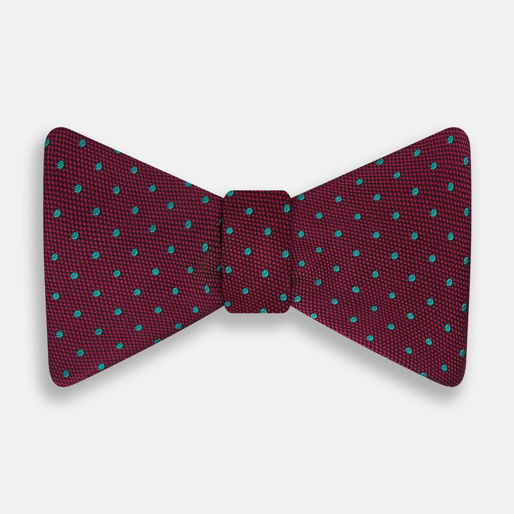 The Turnbull & Asser Green and Magenta Spot Silk Bow Tie, shown on a plain white background, features small, evenly spaced spots—making it an ideal accessory for elevating smart outfits.