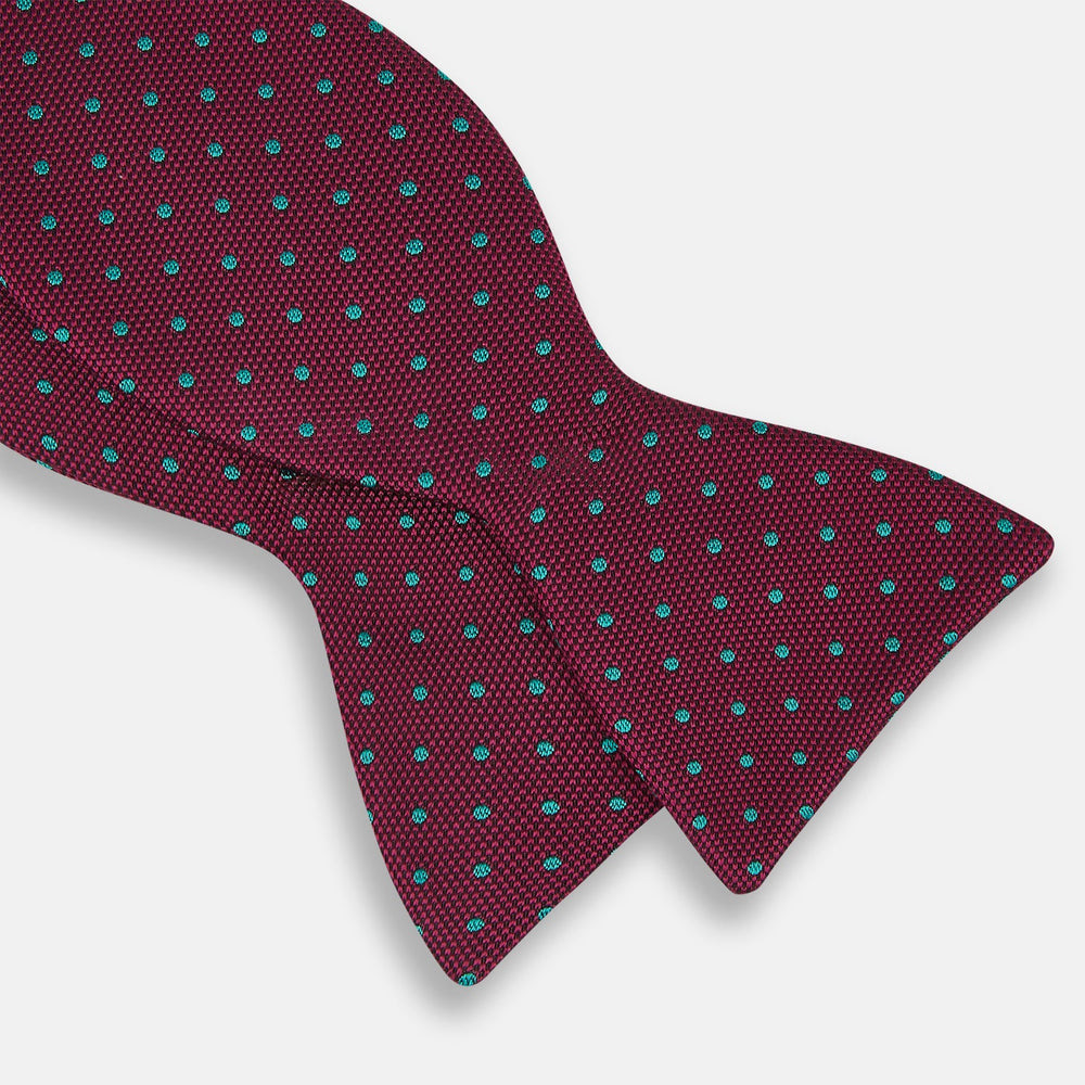 The Turnbull & Asser Green and Magenta Spot Silk Bow Tie, shown on a plain white background, features small, evenly spaced spots—making it an ideal accessory for elevating smart outfits.