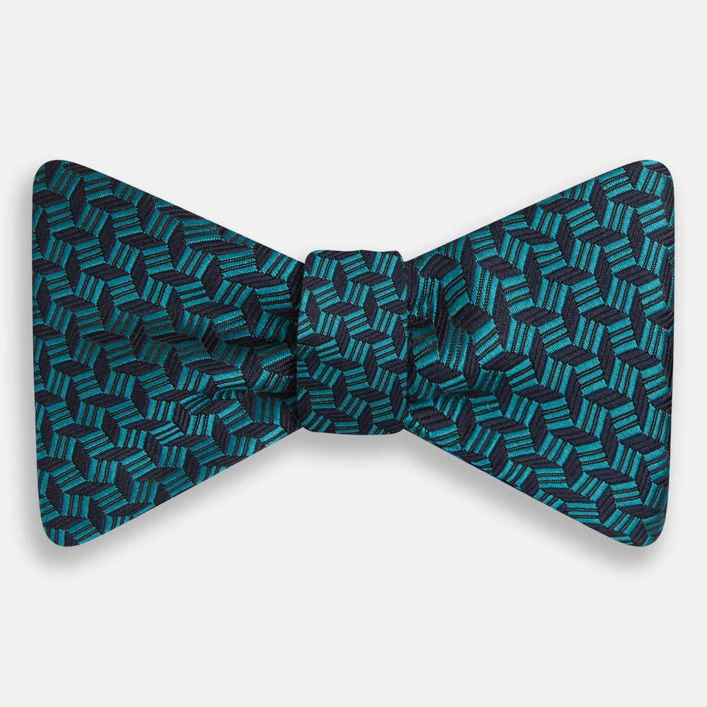 Turnbull & Asser's Turquoise Geometric Silk Bow Tie showcases British elegance with its teal and black cube pattern, set against a white background.