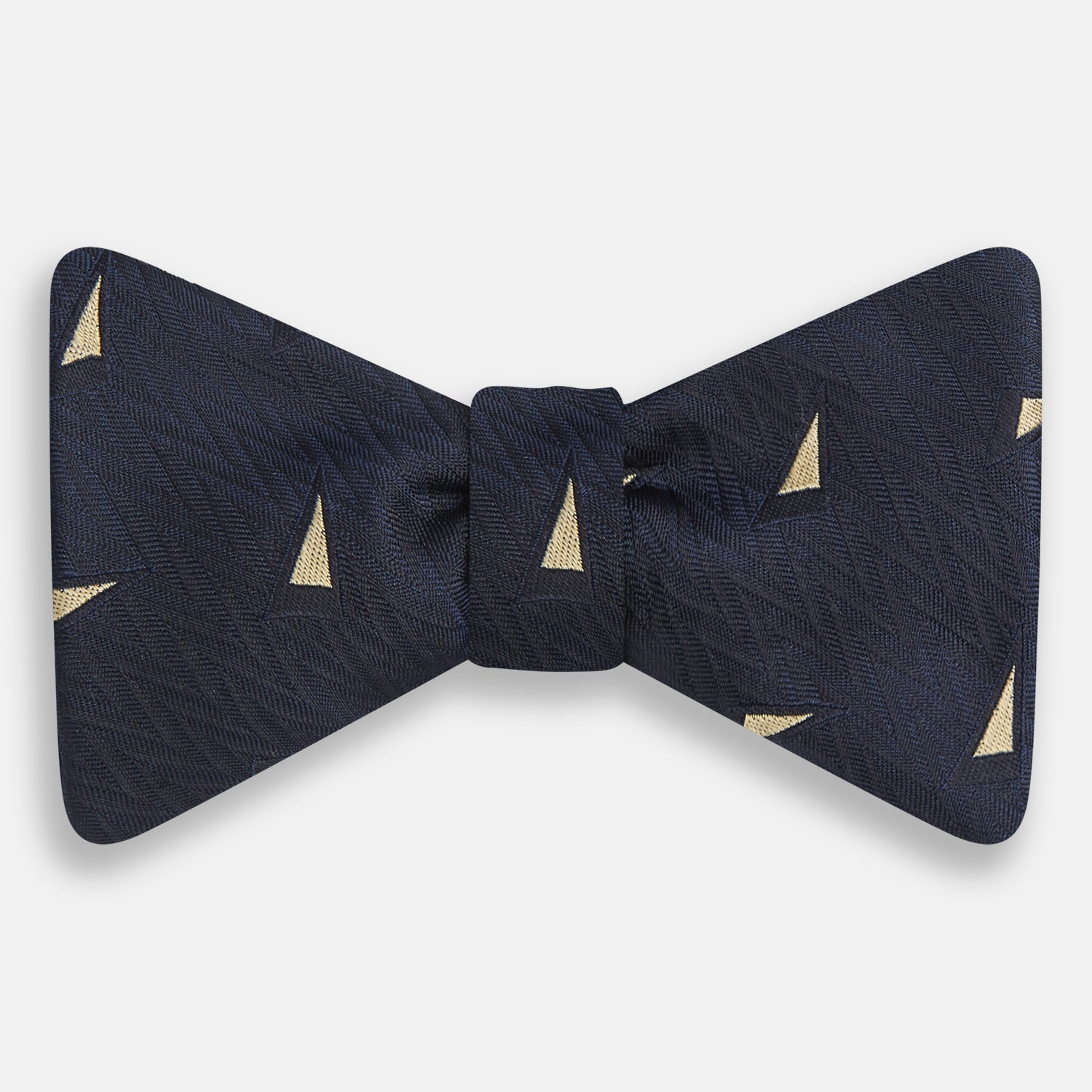 View 1 of product The Navy Triangle Silk Bow Tie by Turnbull & Asser features British elegance with a subtle herringbone pattern and scattered small gold triangle designs.