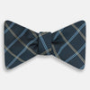 View 1 of product The Turnbull & Asser Navy Triple Check Silk Bow Tie features a navy, light blue, and beige plaid pattern on white, offering British elegance for those who value formal style.