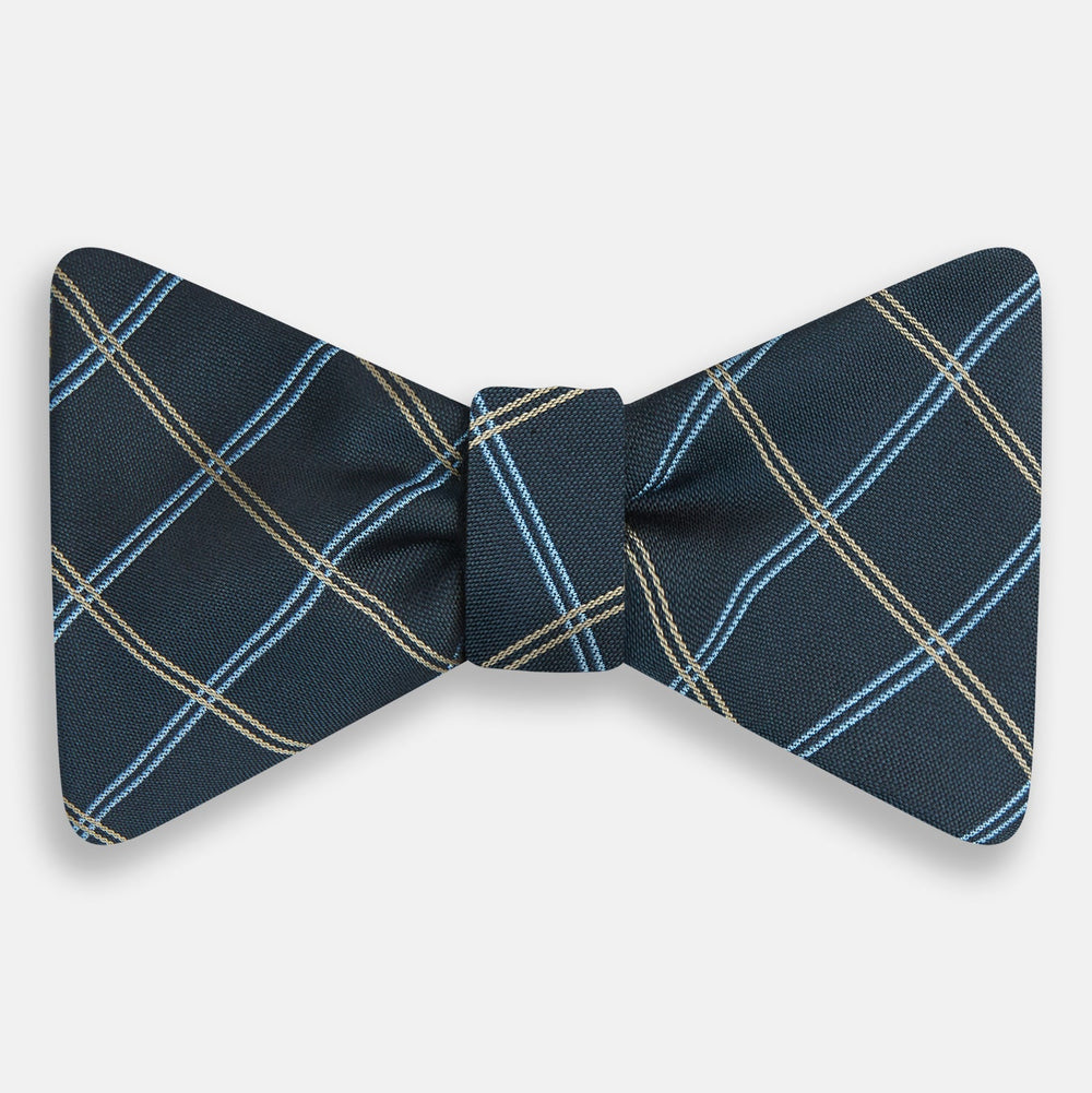 The Turnbull & Asser Navy Triple Check Silk Bow Tie features a navy, light blue, and beige plaid pattern on white, offering British elegance for those who value formal style.