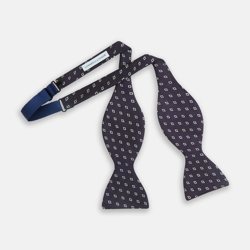 The Turnbull & Asser Blue Diamond Silk Bow Tie features small white diamond motifs on dark navy—perfect for adding classic British elegance to your formal look.