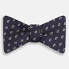 View 1 of product The Turnbull & Asser Blue Diamond Silk Bow Tie features small white diamond motifs on dark navy—perfect for adding classic British elegance to your formal look.