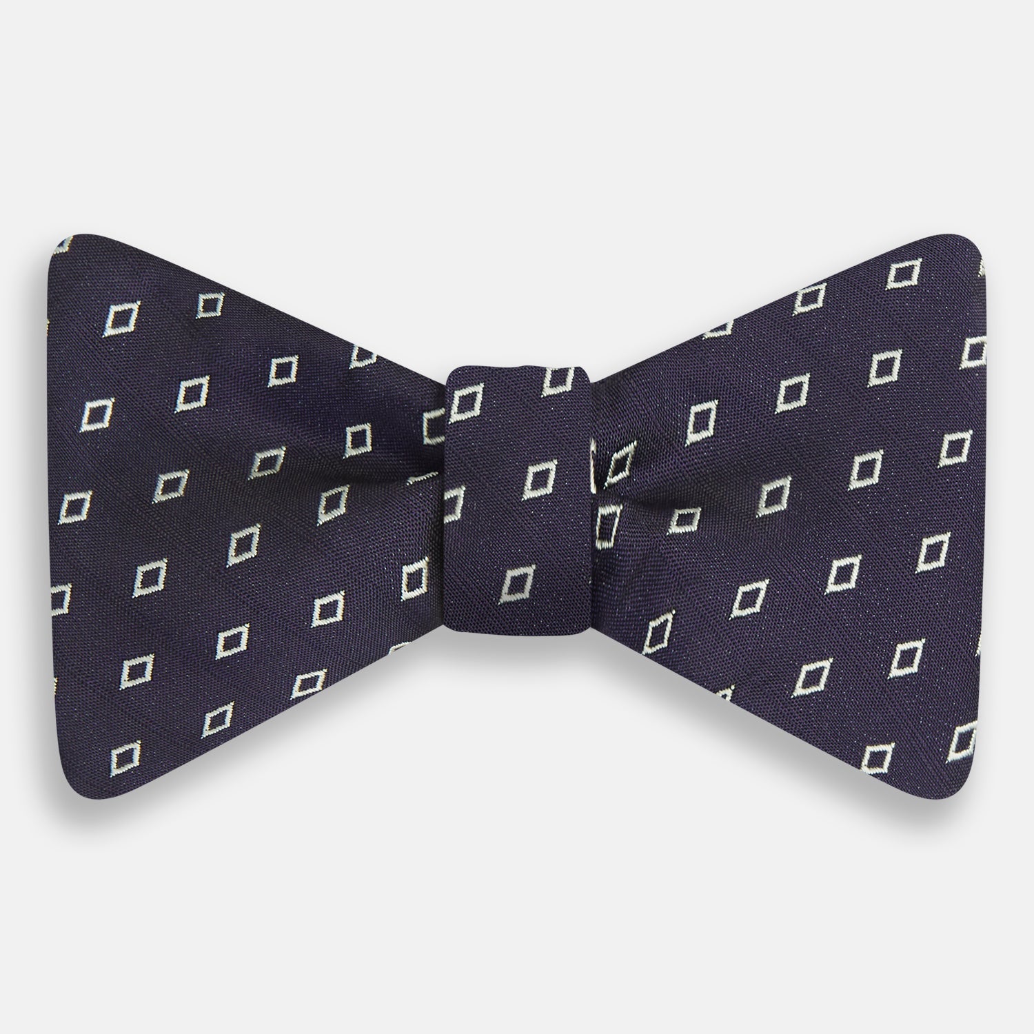 View 1 of product The Turnbull & Asser Blue Diamond Silk Bow Tie features small white diamond motifs on dark navy—perfect for adding classic British elegance to your formal look.