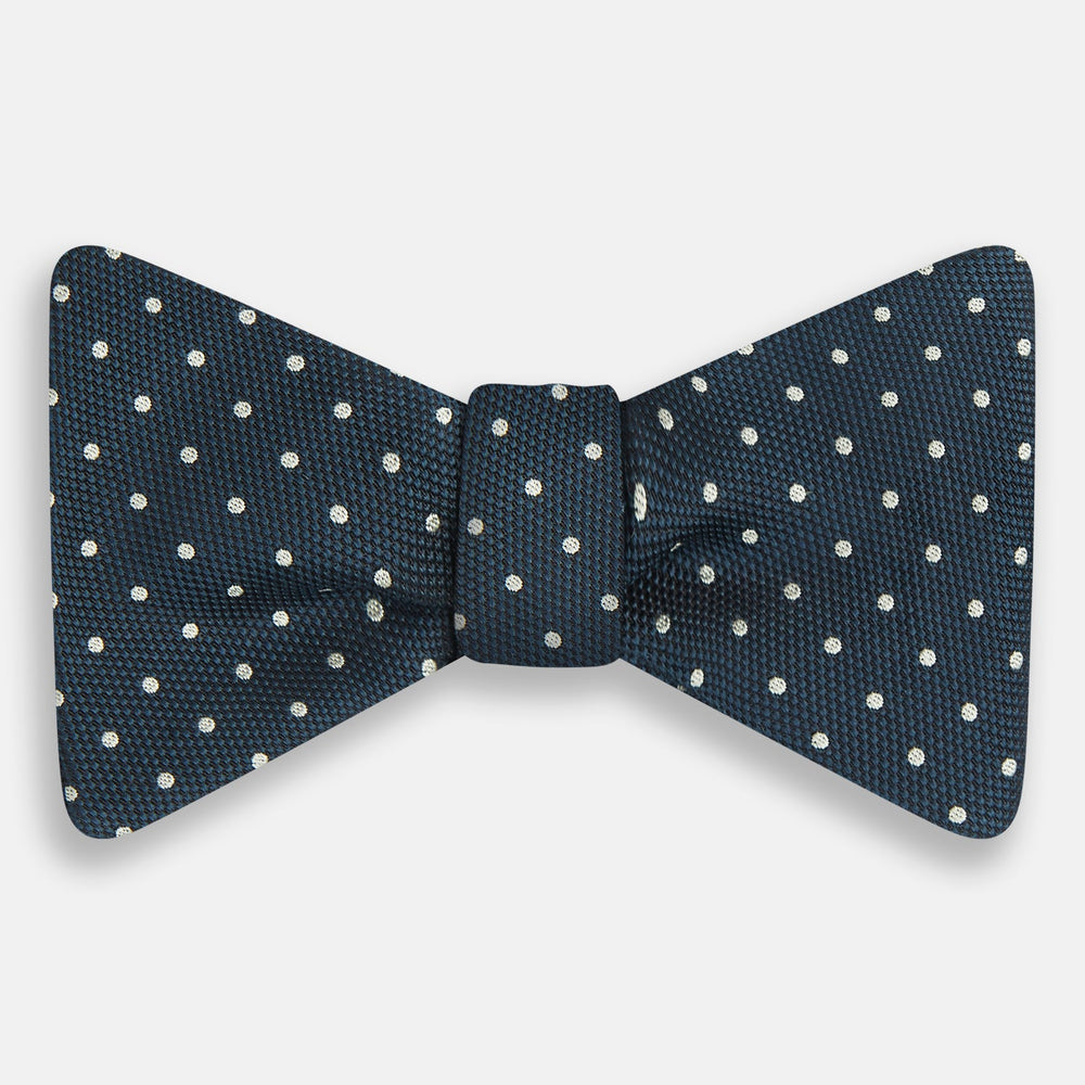 The Turnbull & Asser Navy Micro Dot Silk Bow Tie, shown on a white background, embodies British sophistication and classic formal style.