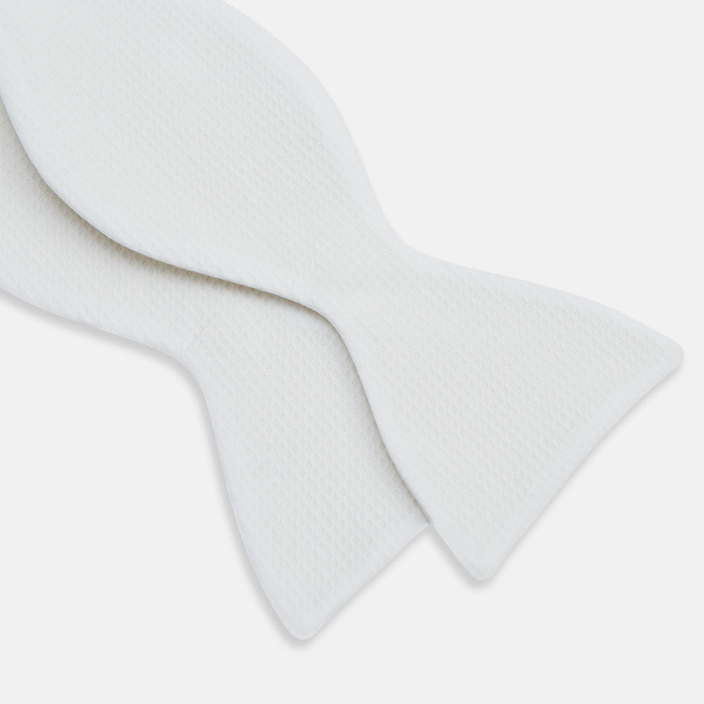 The Turnbull & Asser White Marcella Bow Tie features a classic shape and textured finish, ideal for formal occasions and elegantly presented against a plain white background.