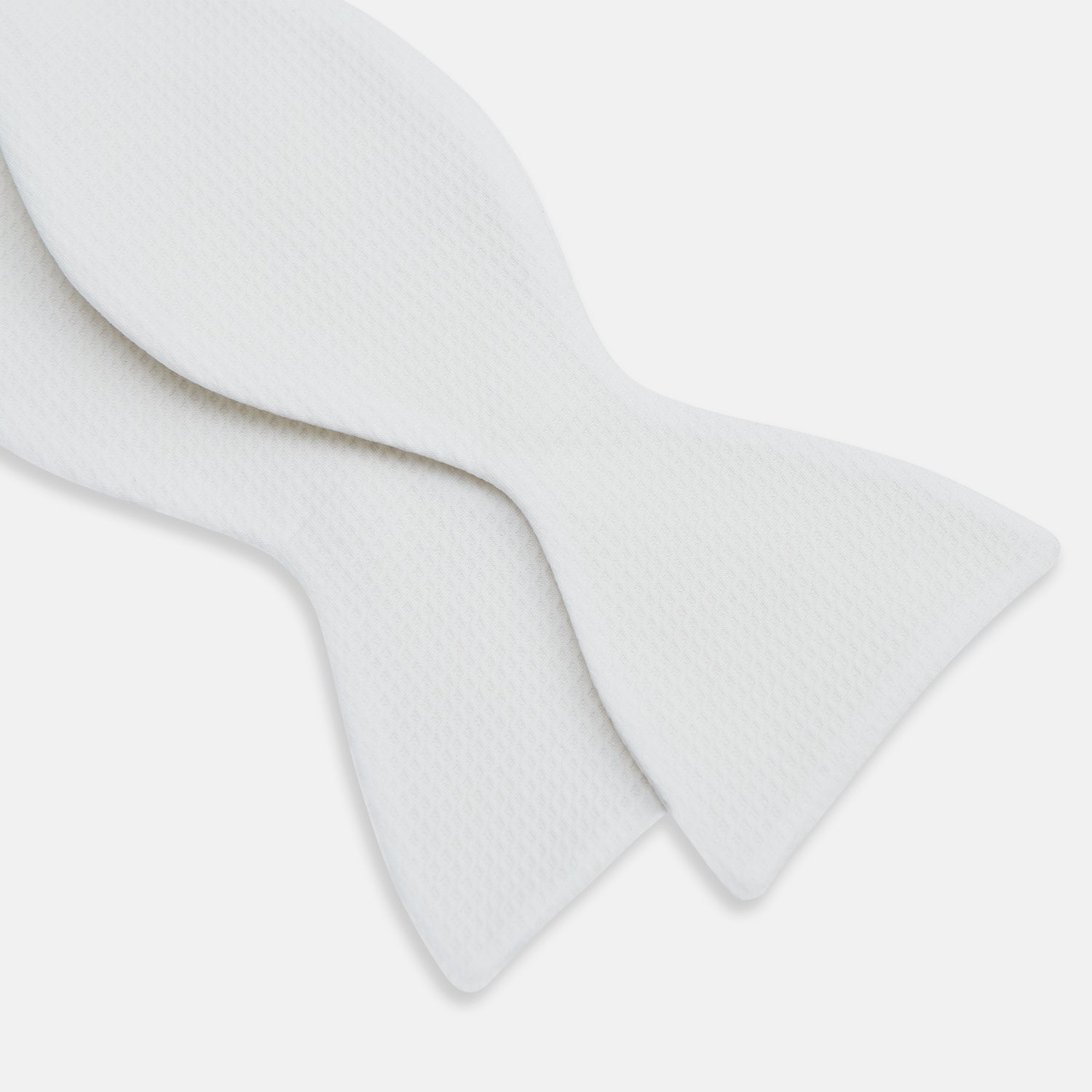 View 3 of product The Turnbull & Asser White Marcella Bow Tie features a classic shape and textured finish, ideal for formal occasions and elegantly presented against a plain white background.
