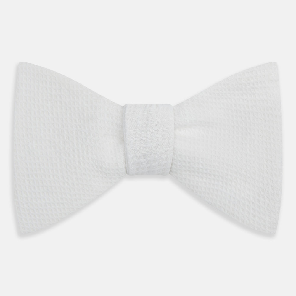 The Turnbull & Asser White Marcella Bow Tie features a classic shape and textured finish, ideal for formal occasions and elegantly presented against a plain white background.