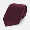 View 1 of product A close-up of the Turnbull & Asser UK Seven-Fold Navy and Red Silk Tie, featuring a small textured check pattern reminiscent of houndstooth, displayed on a plain white background.