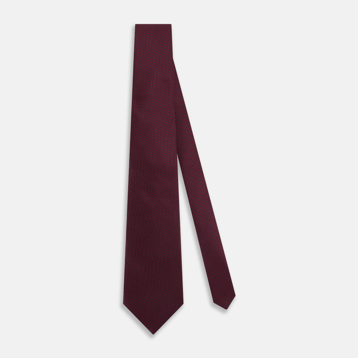 View 2 of product A close-up of the Turnbull & Asser UK Seven-Fold Navy and Red Silk Tie, featuring a small textured check pattern reminiscent of houndstooth, displayed on a plain white background.