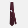View 4 of product A close-up of the Turnbull & Asser UK Seven-Fold Navy and Red Silk Tie, featuring a small textured check pattern reminiscent of houndstooth, displayed on a plain white background.