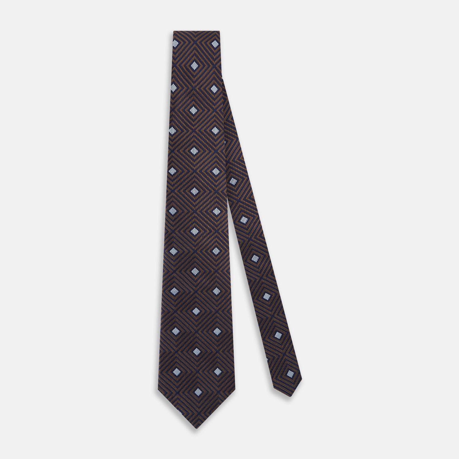 View 2 of product The Tomorrow Never Dies Seven-Fold Silk Tie by Turnbull & Asser UK features a geometric pattern of navy and brown squares with light blue diamond accents, rolled up and displayed on a plain white background.