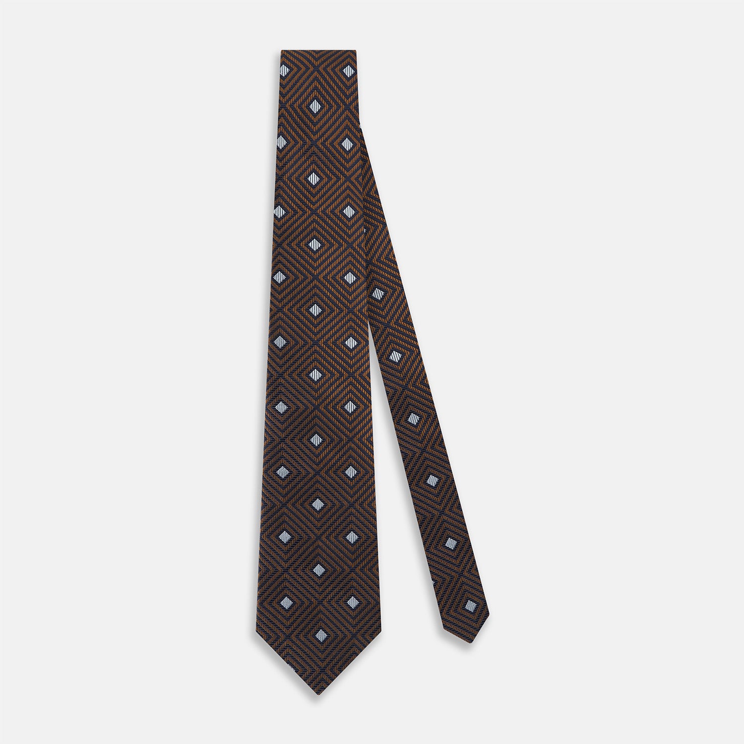 View 2 of product The Turnbull & Asser UK Tomorrow Never Dies Seven-Fold Silk Tie, as seen on James Bond, features a navy blue and brown geometric diamond pattern with silver squares at the center, set on a light background.