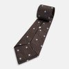 View 5 of product The Turnbull & Asser UK Tomorrow Never Dies Seven-Fold Silk Tie, as seen on James Bond, features a navy blue and brown geometric diamond pattern with silver squares at the center, set on a light background.