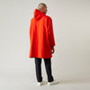 View 4 of product Wearing the Turnbull & Asser Red Walter Sealup Parka with Detachable Liner, black pants, and white sneakers, a person stands in profile against a plain light background—perfect for travel.